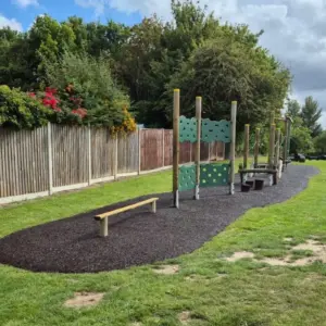 Wooden play equipment with rubber mulch around it