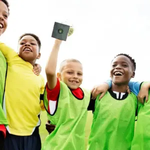 School boys celebrating winning a football match