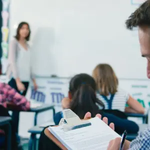 Male inspecting female teacher during class
