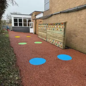 Traverse walll surrounded by rubber mulch with activity circles